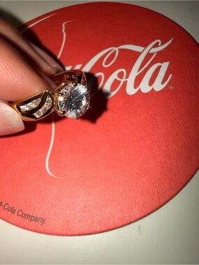 Gold tone solitaire ring with clear center stone